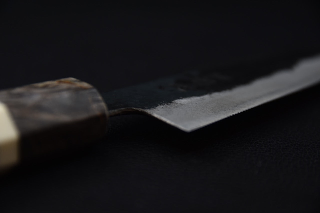 Couteau japonais avec lame brillante sur fond sombre