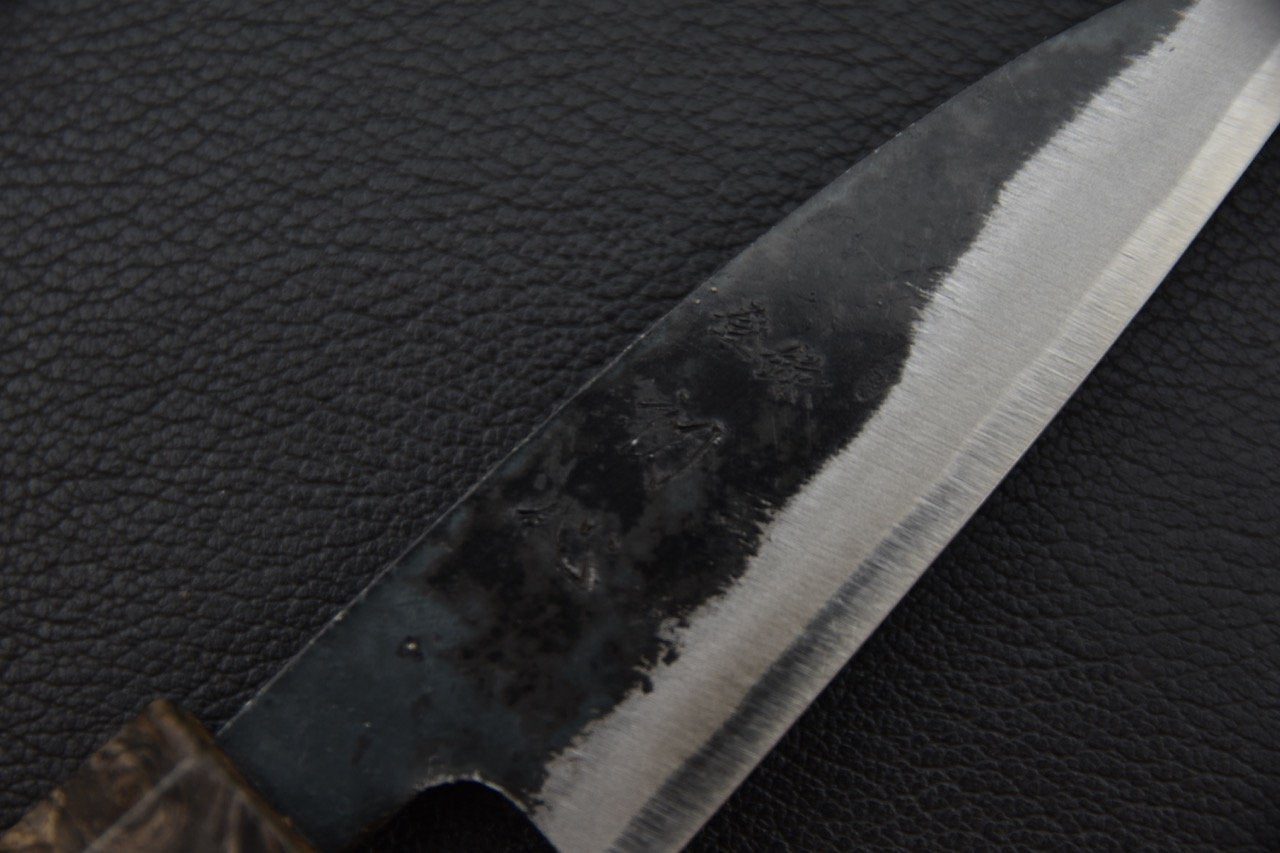 Couteau japonais à lame kurouchi sur fond noir