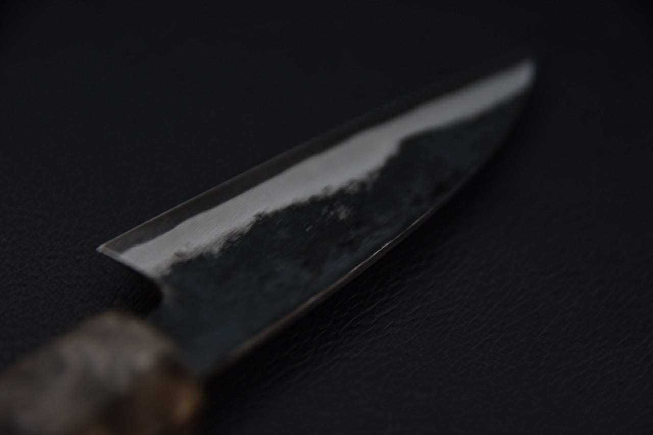 Couteau japonais avec lame martelée sur fond noir 