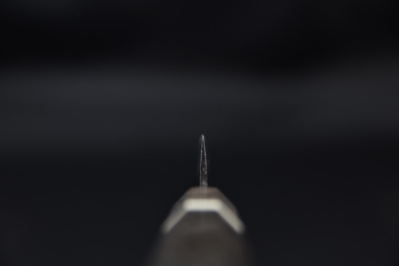 Couteau japonais vu de face sur fond sombre