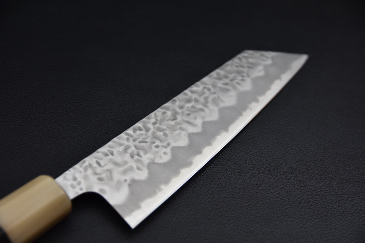 Couteau japonais bunka 170 mm, vue de la lame depuis le talon, finition tsuchime martelée et ligne hagane visible