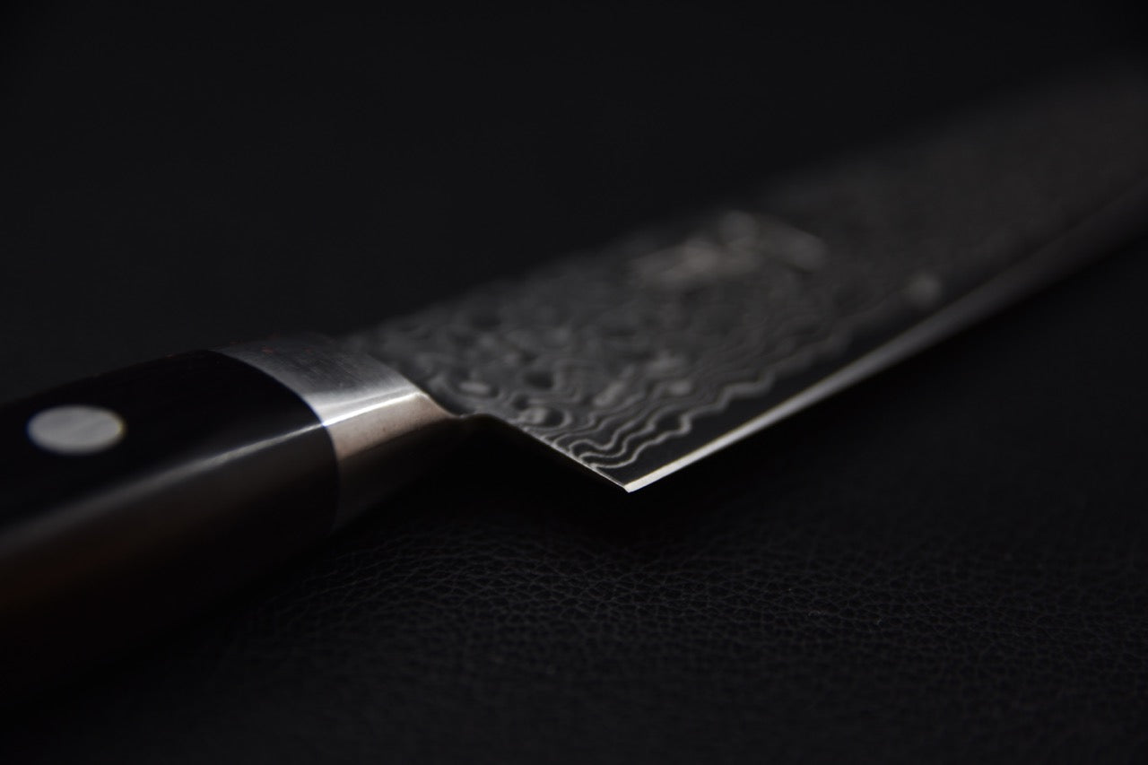 Couteau japonais avec lame damassée sur fond noir