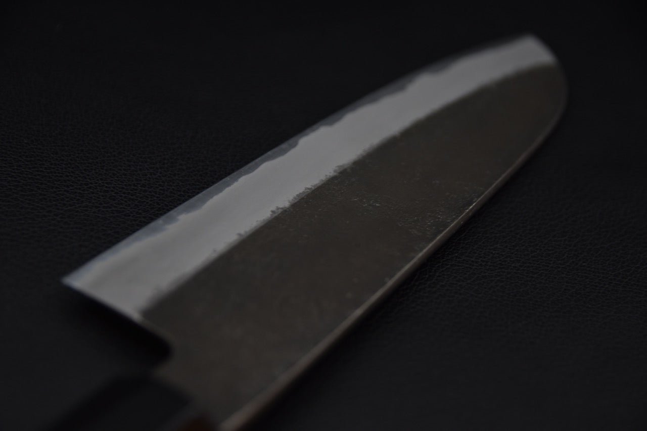 Couteau japonais avec lame polie sur fond sombre