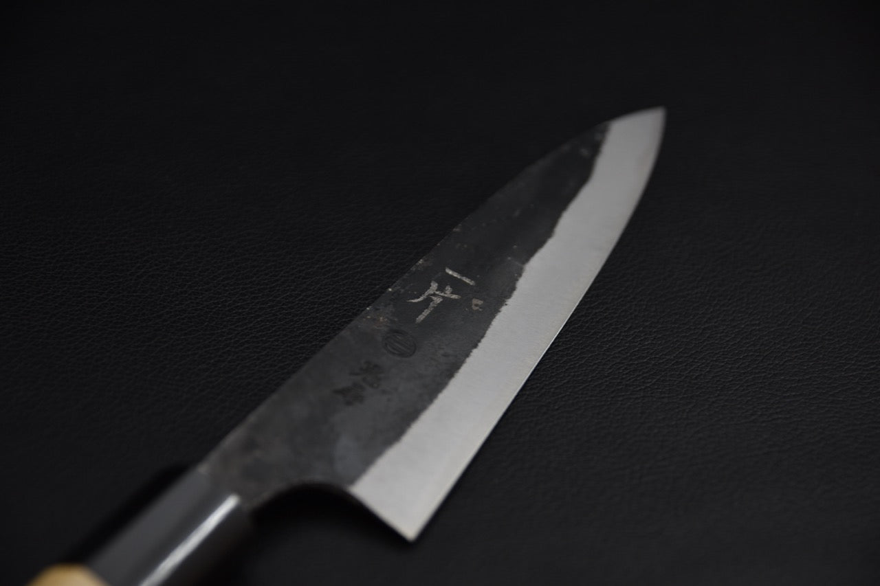 Couteau japonais petty 150 mm, gros plan sur la pointe de la lame kurouchi et biseau poli