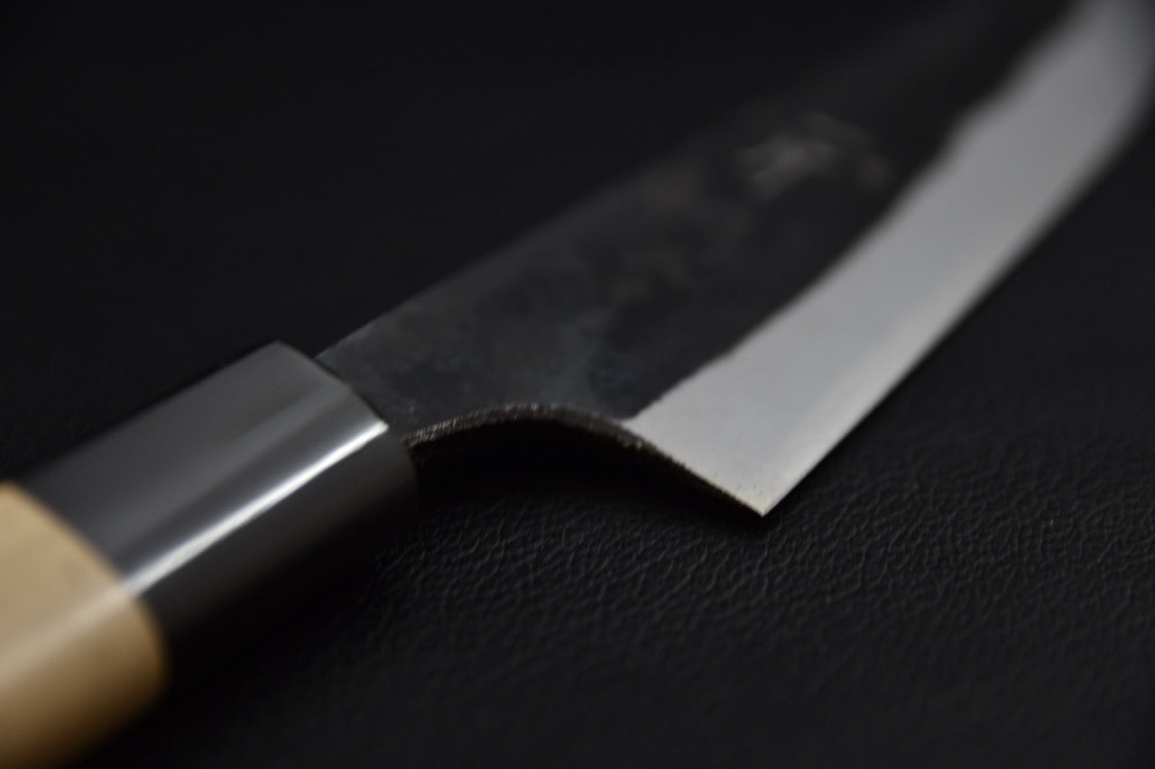 Couteau japonais petty 150 mm, gros plan sur la jonction lame-manche, virole noire et talon de lame