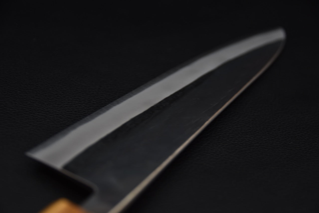 Gros plan sur la lame d'un couteau japonais Gyuto en acier Aogami 2 kurouchi