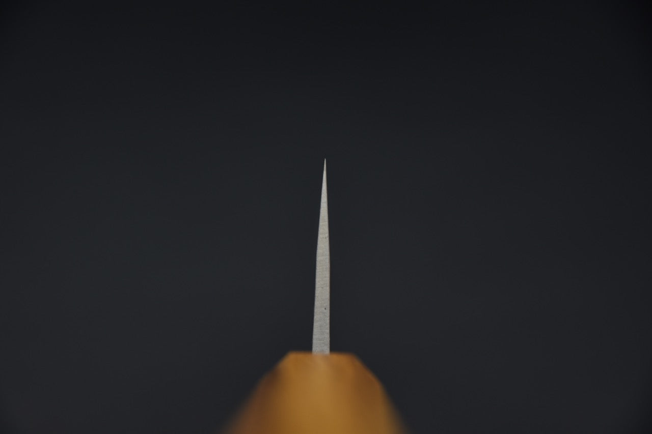 Gros plan sur la lame d'un couteau japonais Gyuto avec manche en chêne et finition kurouchi