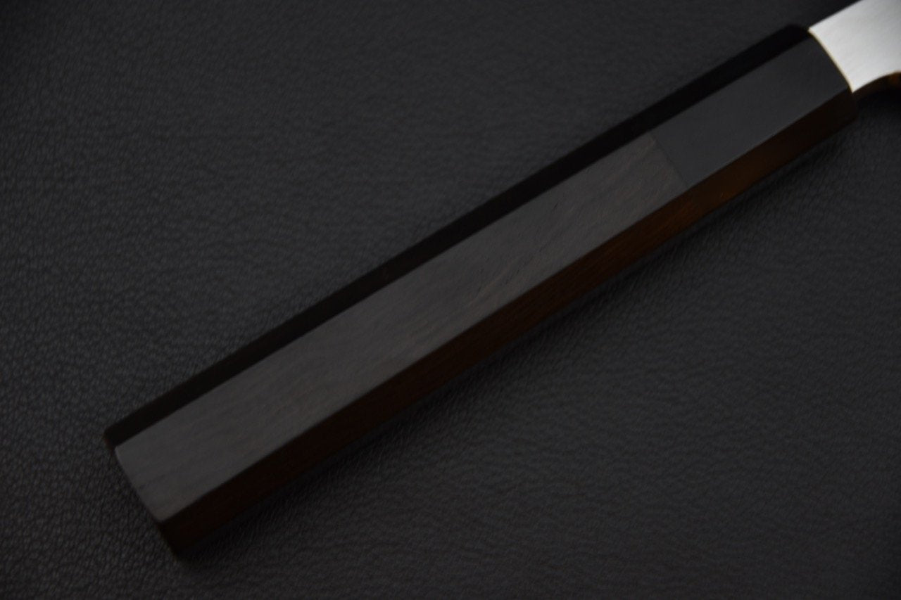 Manche en ébène d'un couteau japonais Kiritsuke yanagiba sur fond noir