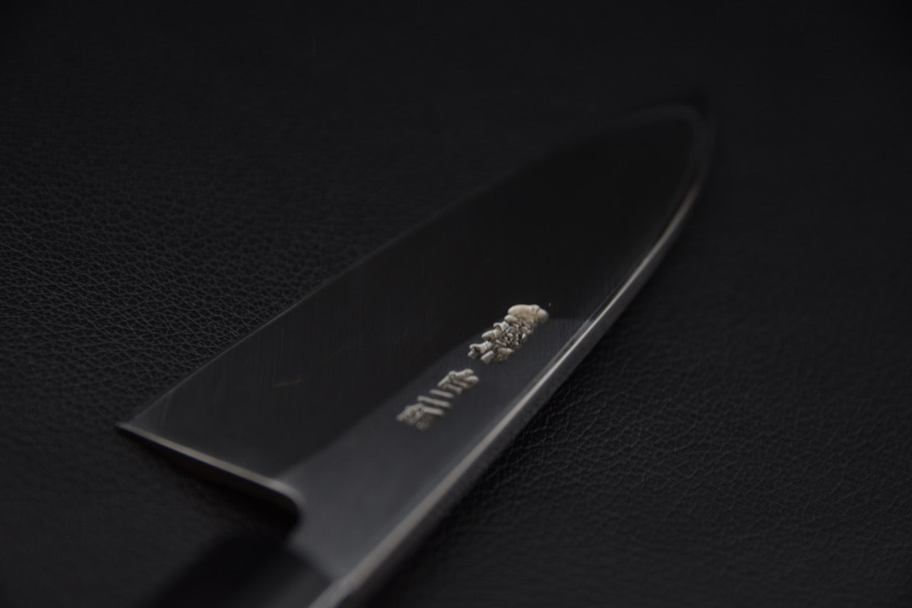 Couteau Deba japonais avec lame en acier Shirogami sur fond noir, vue de derrière