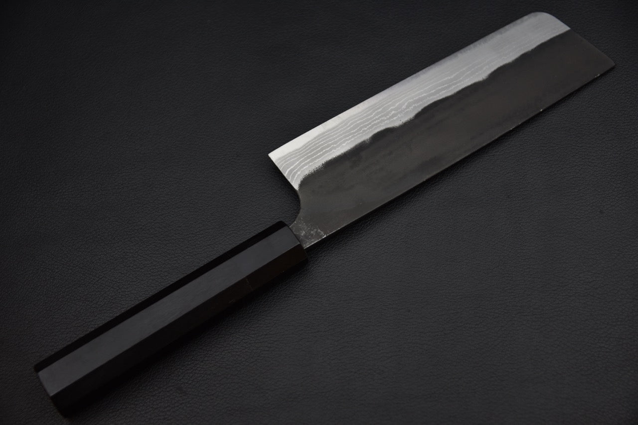 Nakiri couteau japonais — contraste entre la peau de forge noire et le biseau poli