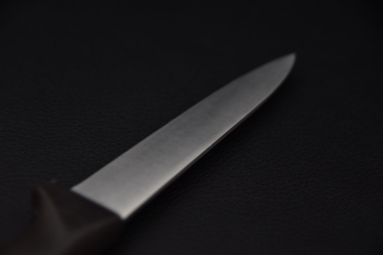 Gros plan sur la lame d'un couteau japonais sur fond noir