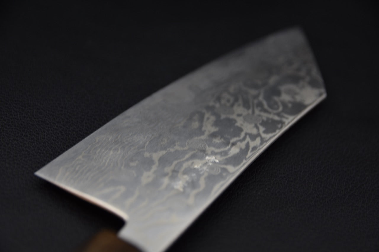 Gros plan sur la lame en acier Damascus du couteau japonais Tsubaki avec motif élégant