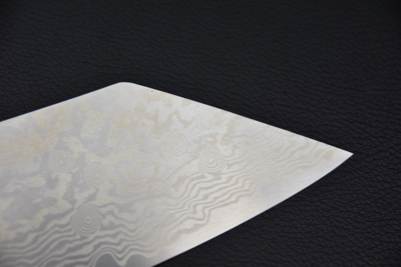 Gros plan sur la pointe de la lame du couteau japonais Tsubaki montrant son motif distinctif