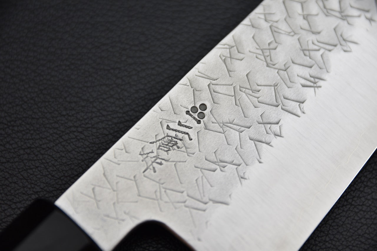 Nigara Hamono santoku 180 mm — détail du motif gravé caractéristique et des kanji sur la lame