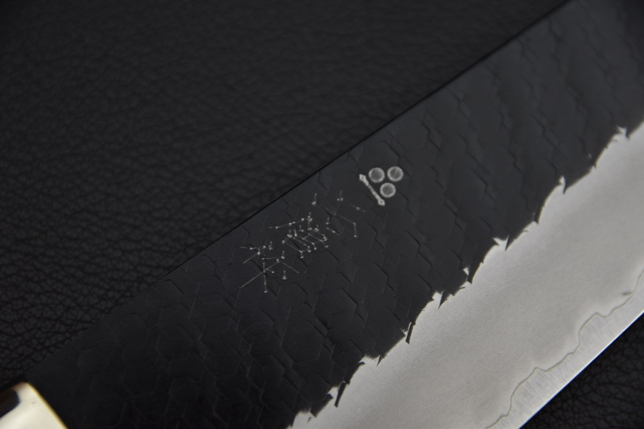 Couteau japonais gyuto 210 mm — gros plan sur les kanji gravés et la finition kurouchi du corps de lame