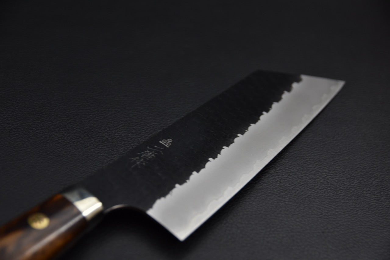 Couteau japonais nakiri SG2 — gros plan sur la lame, finition kurouchi avec texture tsuchime martelée et biseau poli