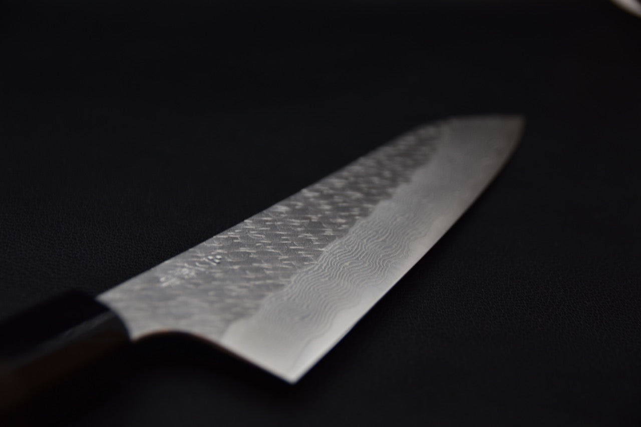 Couteau japonais avec lame damassée sur fond noir 