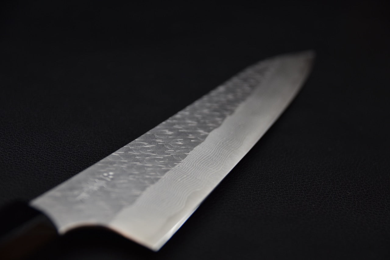 Couteau japonais avec lame damassée sur fond noir 