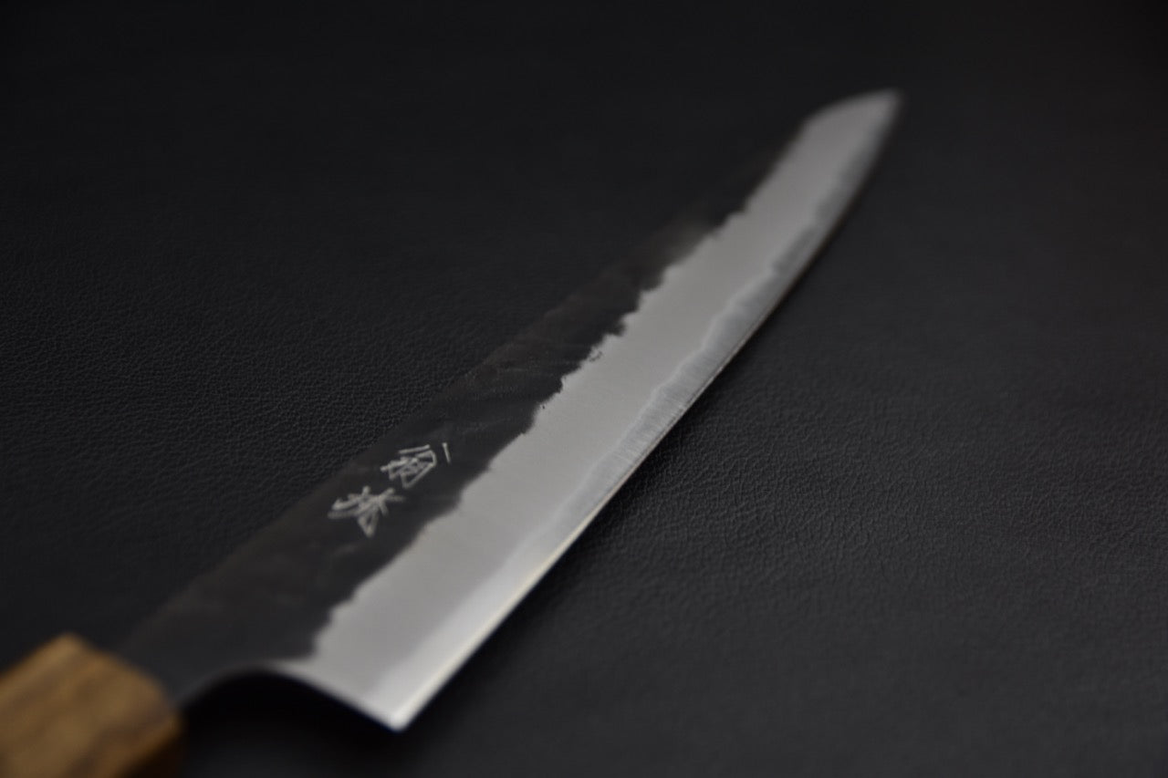 Couteau japonais sujihiki 270 mm — détail de la lame côté droit, finition kurouchi et biseau poli avec kanji gravés