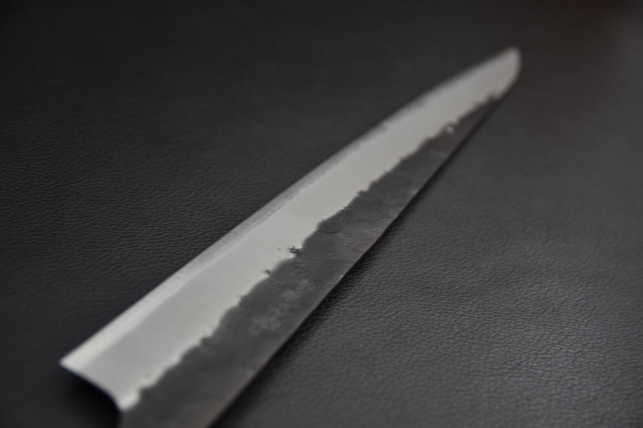 Couteau japonais sujihiki 270 mm — détail du biseau poli et de la ligne hagane ondulée, côté gauche