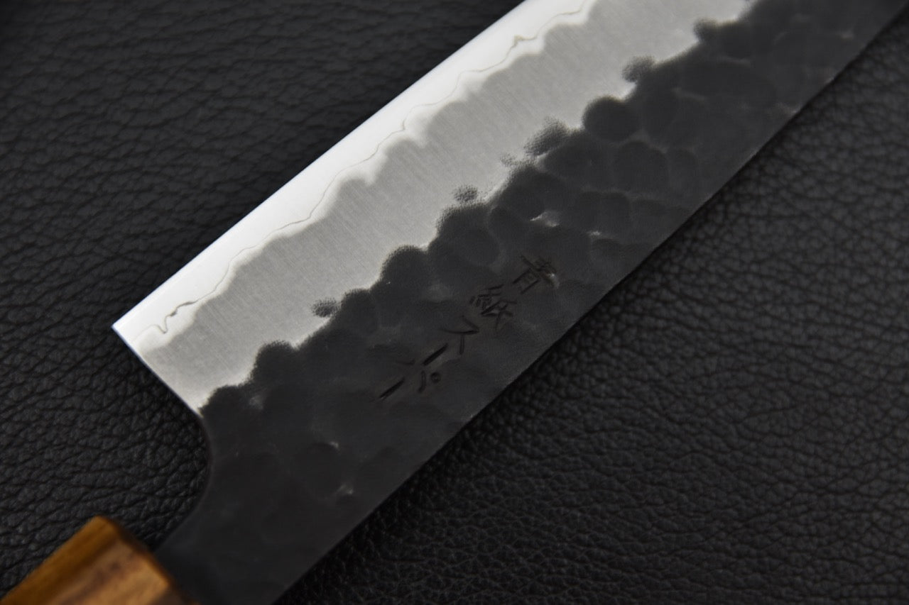 Couteau japonais petty 135 mm — détail du biseau et de la ligne hagane, finition kurouchi et tranchant poli