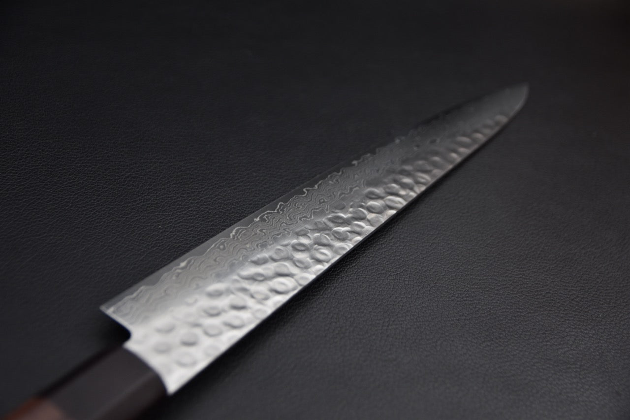Sujihiki japonais 240 mm — vue de la lame côté gauche, finition damas tsuchime et ligne hagane