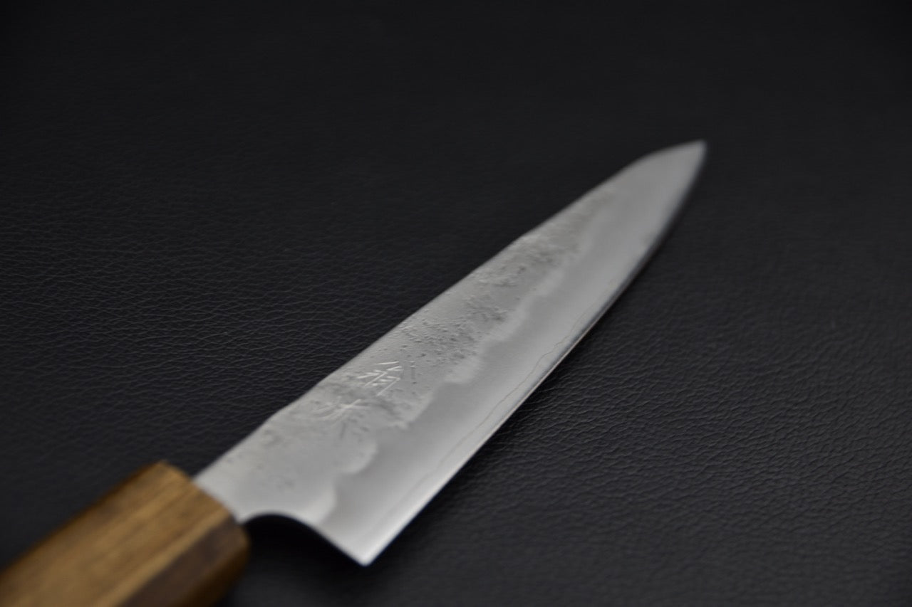 Couteau japonais 135 mm, vue de profil rapproché sur la lame effilée avec finition kasumi et kanji gravés, manche wa en bois — Stay Sharp Montréal.