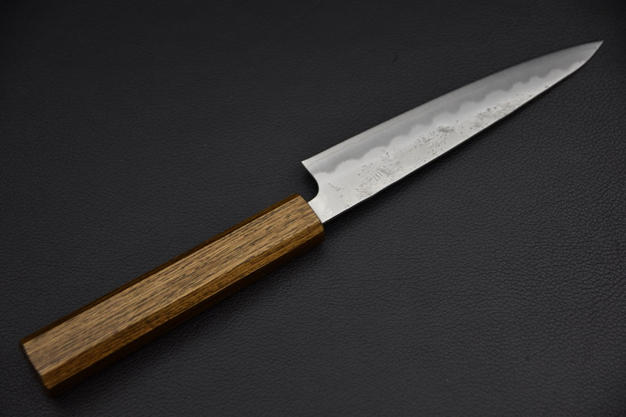 Couteau japonais 135 mm, vue complète du couteau posé sur fond noir, manche wa octogonal en bois brun et lame à profil effilé — Stay Sharp Montréal.