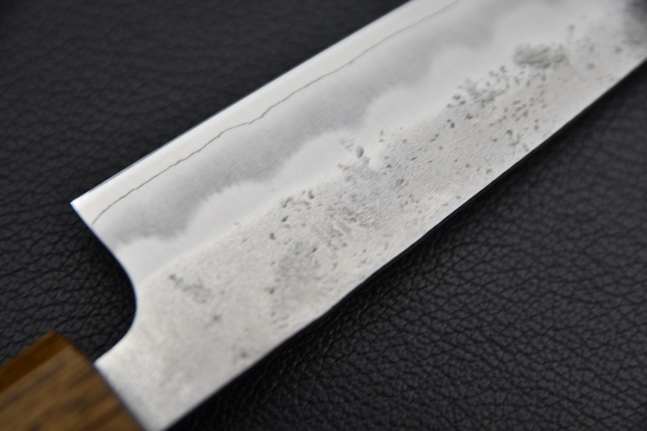 Couteau japonais 135 mm, gros plan sur la partie haute de la lame près du manche, finition kasumi et texture forgée visible — Stay Sharp Montréal.