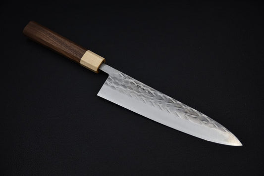 Couteau de cuisine japonais avec lame damassée gravée et manche en bois sur fond noir