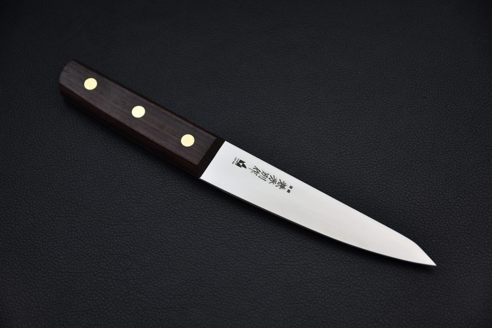 Japanese paring knife with a stainless steel blade, dark wooden handle, and three brass rivets on a black textured background.