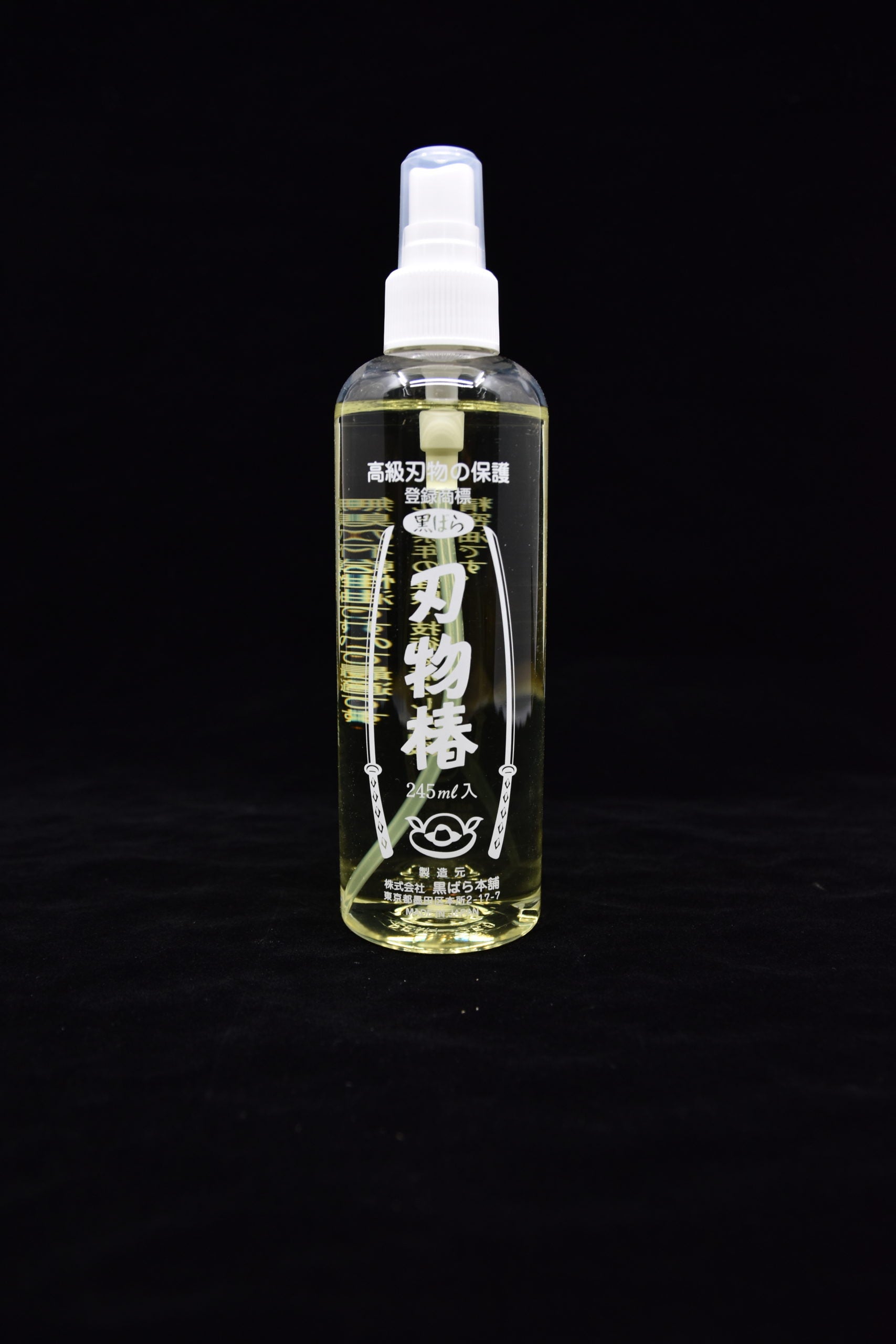 Bottle of Japanese blade oil with a spray nozzle, labeled in Japanese, standing upright against a black background.